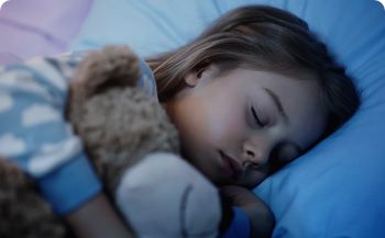 Young girl sleeping and holding a teddy bear